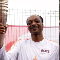 Snoop Dogg carrega tocha olímpica de Paris 2024.