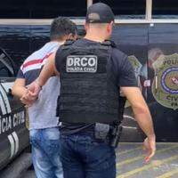 A imagem mostra o preso sendo conduzido por um policial civil.