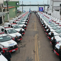 A imagem em destaque mostra vários policiais militares ao lado de diversas viaturas da corporação.