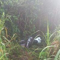 A imagem em destaque mostra a motocicleta em que a vítima estava e parou em uma área de mata após o sinistro.